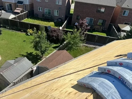 Prepared roof deck with underlayment staged at the ridge